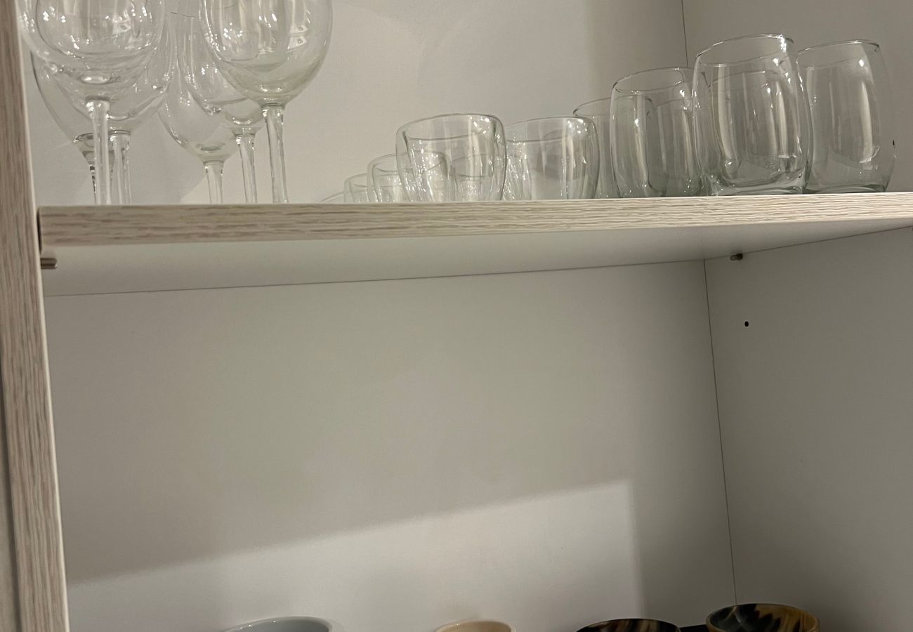 Detalle de la cocina del departamento Arrayán 1A con vajilla, cubertería y utensilios de cocina para los huéspedes.